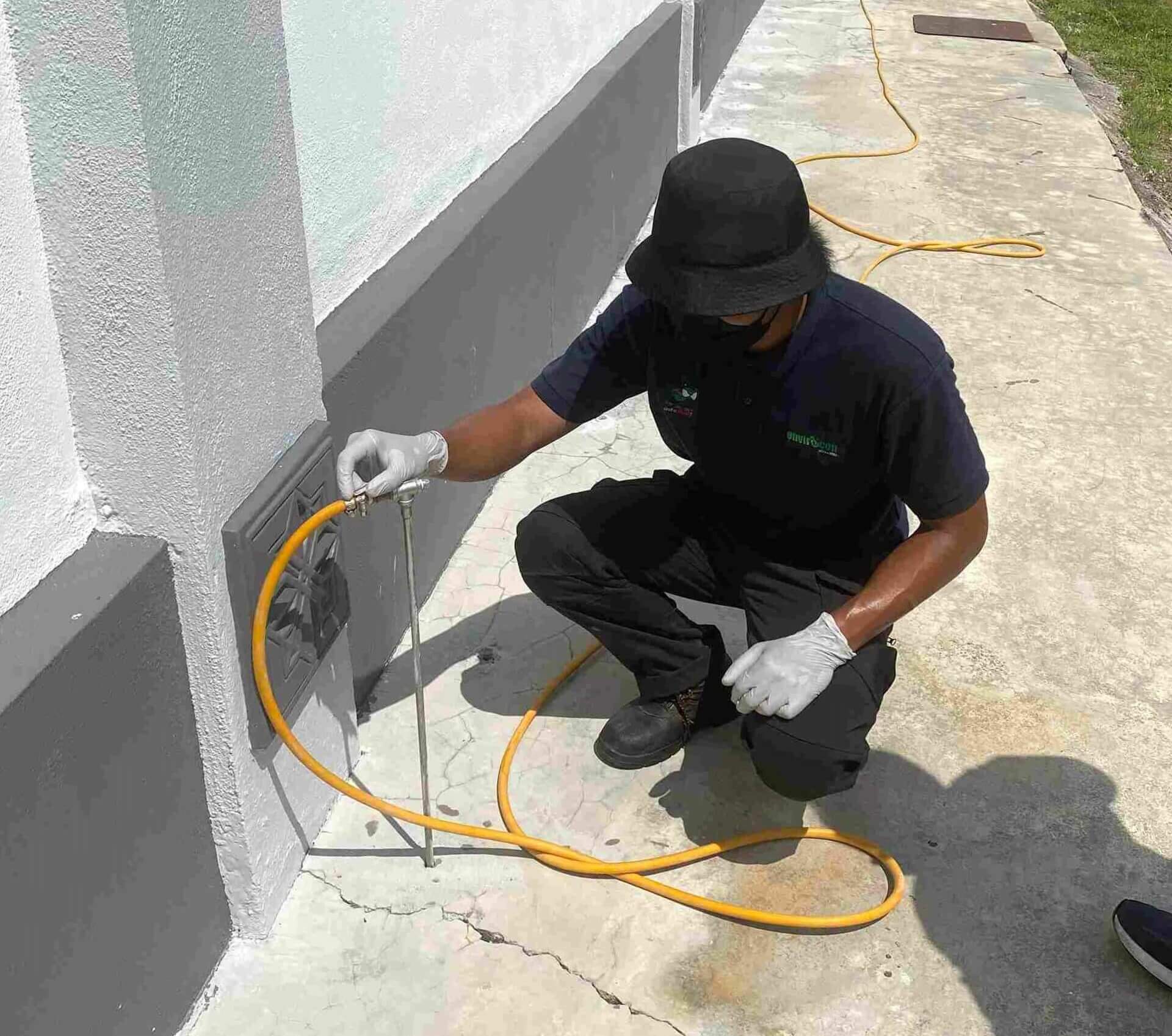 A man is installing corrective soil treatment as a part of termite control service.