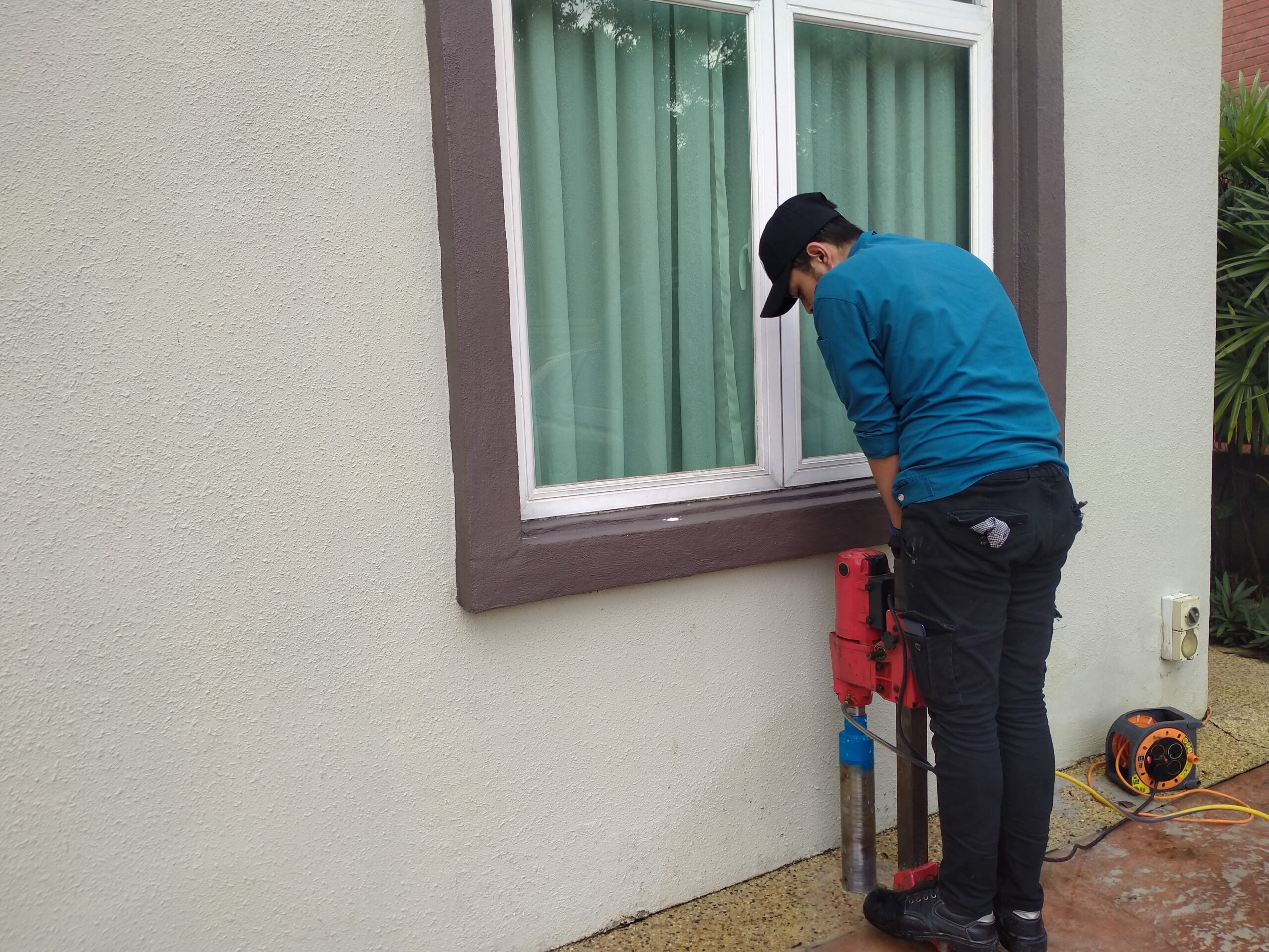 Corrective soil treatment is being done by a staff during termite pest control service.